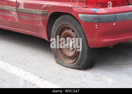 Voiture rouge sur route, pneu à plat Banque D'Images