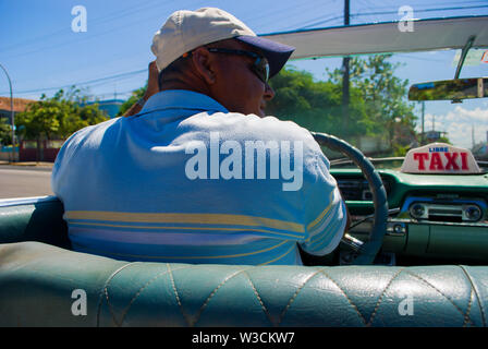 Varadero - Cuba / le 11 octobre 2011, chauffeur de taxi cubain américain classique dans sa voiture décapotable emmène les touristes à l'hôtel Banque D'Images