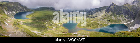 Large panorama de montagne de Rila lakes d'un point de vue dramatique avec ciel, brouillard épais et lisse, réfléchissant, lacs glaciaires d'un bleu saphir Banque D'Images