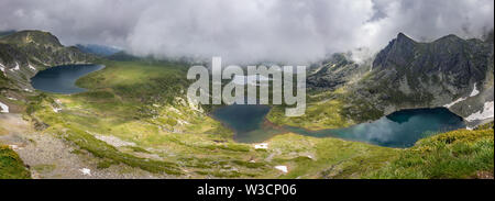 Large panorama de montagne de Rila lakes d'un point de vue dramatique avec ciel, brouillard épais et lisse, réfléchissant, lacs glaciaires d'un bleu saphir Banque D'Images