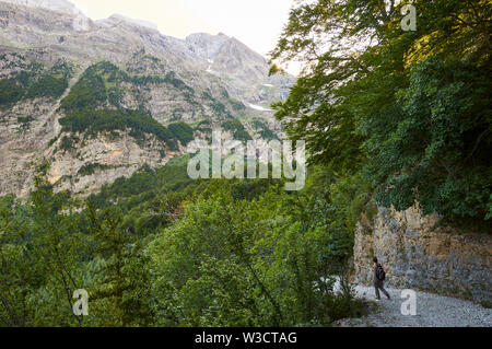 Female hiker en sentier de randonnée de la vallée de Pineta au crépuscule dans Parc national Ordesa y Monte Perdido (Sobrarbe, Huesca, Pyrénées, Aragon, Espagne) Banque D'Images