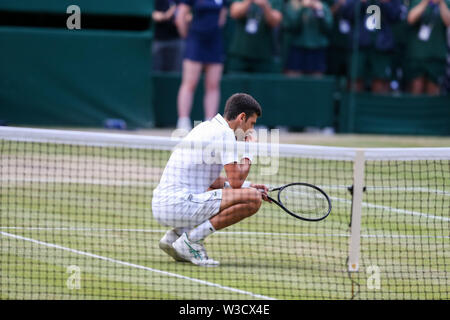 Wimbledon, Londres, Royaume-Uni. 14 juillet 2019. Novak Djokovic la Serbie de mange de l'herbe pour célébrer sa victoire après la finale du tournoi de tennis sur gazon de Wimbledon le Championships contre Roger Federer de la Suisse à l'All England Lawn Tennis et croquet Club à Londres, Angleterre le 14 juillet 2019. Credit : AFLO/Alamy Live News Banque D'Images