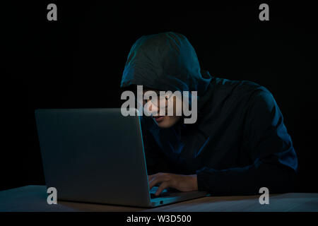 Pirate informatique travaillant dans une pièce sombre Banque D'Images