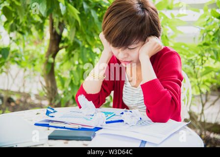 Vue de dessus du jeune femme qui travaille à l'aide d'ordinateur portable et de la lecture rapport annuel document de travail. Femme d'affaires travaillant à son bureau. Banque D'Images