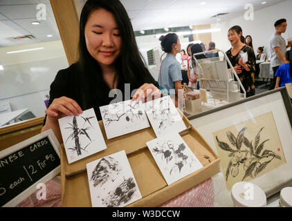 Vancouver, Canada. 14 juillet, 2019. Un artiste affiche quelques cartes postales peinture chinoise au cours de la Creative Chinatown juste à Chinatown House à Vancouver, Canada, le 14 juillet 2019. Chinatown créative est une journée juste pour les jeunes artistes et artisans de présenter leur créativité dérivée de la Vancouver Chinatown et le mode de vie des caractéristiques culturelles. Credit : Liang Sen/Xinhua/Alamy Live News Banque D'Images