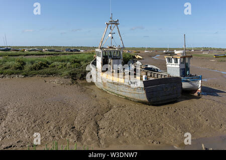 Des bateaux de pêche à marée basse dans le port de marée de Brancaster Staithe, Norfolk, UK Banque D'Images