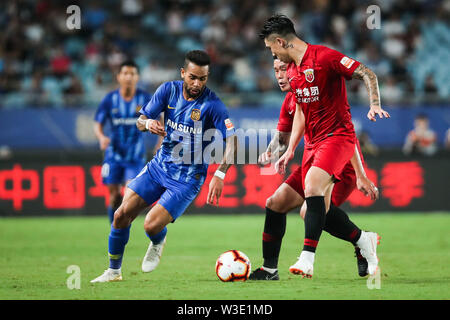 Joueur de football brésilien Alex Teixeira, gauche, de Jiangsu Suning passe le ballon contre des joueurs de la Shanghai EPOP dans leur 17e match au cours de l'Association de football chinoise 2019 Super League (CSL) dans la ville de Nanjing, Jiangsu province de Chine orientale, le 13 juillet 2019. Epop Shanghai Jiangsu défait Suning 3-0. Banque D'Images