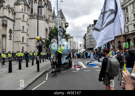 Royal Courts of Justice, London, UK. 15 juillet, 2019. Rébellion d'extinction les changements climatiques protestataires bloquent la rue devant les cours royales de justice avec leur nouveau bateau Polly Higgins. Crédit : Matthieu Chattle/Alamy Live News Banque D'Images
