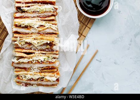 Katsu Sando - escalope traditionnelle japonaise avec sandwich porc frit chou,japonais,la mayonnaise et la sauce tonkatsu sur un fond clair close-up Banque D'Images