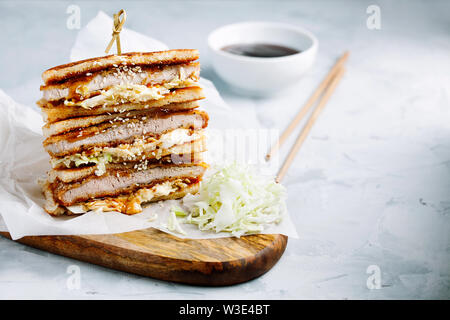 Katsu Sando - escalope traditionnelle japonaise avec sandwich porc frit chou,japonais,la mayonnaise et la sauce tonkatsu sur un fond clair close-up Banque D'Images