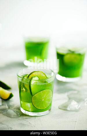Tendance maison thé vert matcha glacé ou de la limonade avec le concombre et citron vert dans un verre sur fond gris clair avec copie espace pour le texte Banque D'Images