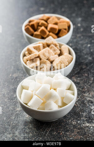 Cubes de sucre blanc et brun dans des bols. Banque D'Images