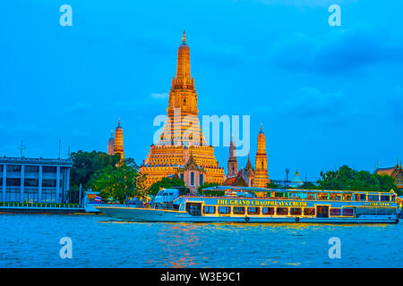 BANGKOK, THAÏLANDE - 22 avril 2019 : Le grand bateau de croisière naviguant illuminé le long de la rivière Chao Phraya passe par le Wat Arun temple, le 22 avril à Bangko Banque D'Images