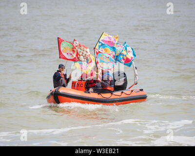 Sheerness, Kent, UK. 15 juillet, 2019. T100 Walking Festival est organisé par arts group Kinetika, qui comprend une série de 15 jours de marche sur les deux côtés de l'estuaire de la Tamise. Aujourd'hui, les organisateurs et les participants ont traversé l'estuaire de la Tamise avec l'aide de l'estuaire de Thames Yacht Club (Essex) dans deux de leurs bateaux et d'atterrir à l'île de Sheppey du Club de Voile cale à Sheerness, Kent, pour rencontrer d'autres marcheurs qui prennent part à la marche d'aujourd'hui de Sheerness de Minster sur mer. Credit : James Bell/Alamy Live News Banque D'Images