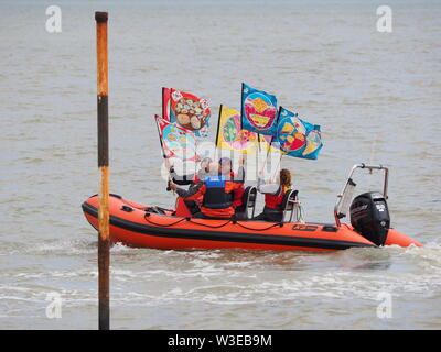 Sheerness, Kent, UK. 15 juillet, 2019. T100 Walking Festival est organisé par arts group Kinetika, qui comprend une série de 15 jours de marche sur les deux côtés de l'estuaire de la Tamise. Aujourd'hui, les organisateurs et les participants ont traversé l'estuaire de la Tamise avec l'aide de l'estuaire de Thames Yacht Club (Essex) dans deux de leurs bateaux et d'atterrir à l'île de Sheppey du Club de Voile cale à Sheerness, Kent, pour rencontrer d'autres marcheurs qui prennent part à la marche d'aujourd'hui de Sheerness de Minster sur mer. Credit : James Bell/Alamy Live News Banque D'Images