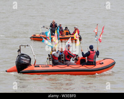 Sheerness, Kent, UK. 15 juillet, 2019. T100 Walking Festival est organisé par arts group Kinetika, qui comprend une série de 15 jours de marche sur les deux côtés de l'estuaire de la Tamise. Aujourd'hui, les organisateurs et les participants ont traversé l'estuaire de la Tamise avec l'aide de l'estuaire de Thames Yacht Club (Essex) dans deux de leurs bateaux et d'atterrir à l'île de Sheppey du Club de Voile cale à Sheerness, Kent, pour rencontrer d'autres marcheurs qui prennent part à la marche d'aujourd'hui de Sheerness de Minster sur mer. Credit : James Bell/Alamy Live News Banque D'Images