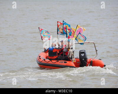 Sheerness, Kent, UK. 15 juillet, 2019. T100 Walking Festival est organisé par arts group Kinetika, qui comprend une série de 15 jours de marche sur les deux côtés de l'estuaire de la Tamise. Aujourd'hui, les organisateurs et les participants ont traversé l'estuaire de la Tamise avec l'aide de l'estuaire de Thames Yacht Club (Essex) dans deux de leurs bateaux et d'atterrir à l'île de Sheppey du Club de Voile cale à Sheerness, Kent, pour rencontrer d'autres marcheurs qui prennent part à la marche d'aujourd'hui de Sheerness de Minster sur mer. Credit : James Bell/Alamy Live News Banque D'Images