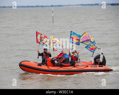 Sheerness, Kent, UK. 15 juillet, 2019. T100 Walking Festival est organisé par arts group Kinetika, qui comprend une série de 15 jours de marche sur les deux côtés de l'estuaire de la Tamise. Aujourd'hui, les organisateurs et les participants ont traversé l'estuaire de la Tamise avec l'aide de l'estuaire de Thames Yacht Club (Essex) dans deux de leurs bateaux et d'atterrir à l'île de Sheppey du Club de Voile cale à Sheerness, Kent, pour rencontrer d'autres marcheurs qui prennent part à la marche d'aujourd'hui de Sheerness de Minster sur mer. Credit : James Bell/Alamy Live News Banque D'Images