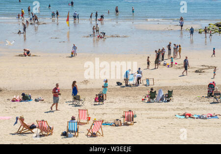 Lyme Regis, dans le Dorset, UK. 15 juillet 2019. Météo France : brulante St Swithin's Day sunshine à Lyme Regis. Les visiteurs se détendre sur la plage à la station balnéaire de Lyme Regis par une chaude et ensoleillée St Swithin's (Swithun's) 24. La légende veut que si le soleil brille sur St Swithin's Day puis 40 jours de soleil suivra. Credit : Celia McMahon/Alamy Live News. Banque D'Images