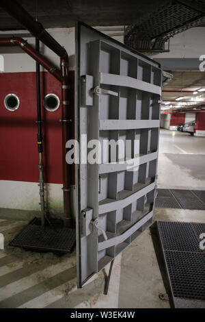 Détails avec le heavy metal portes d'une explosion nucléaire (ABRI) abri, quatre histoires sous la surface du sol, dans une grande place de parking souterrain. Banque D'Images