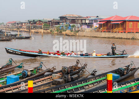 Haspres Thauk, Myanmar - Avril 2019 : Birman traditionnel maison flottante reflétant dans l'eau du lac Inle. Bateaux sur l'avant-plan. Banque D'Images