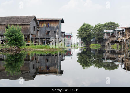 Haspres Thauk, Myanmar - Avril 2019 : Birman traditionnel maison flottante reflétant dans l'eau du lac Inle. Banque D'Images