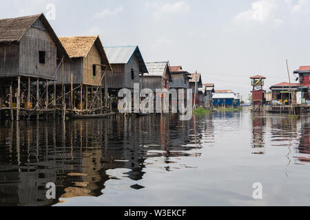Haspres Thauk, Myanmar - Avril 2019 : Birman traditionnel maison flottante reflétant dans l'eau du lac Inle. Banque D'Images