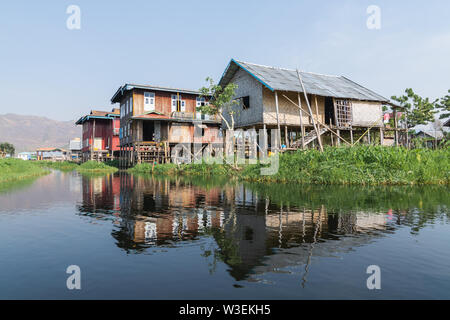 Haspres Thauk, Myanmar - Avril 2019 : Birman traditionnel maison flottante reflétant dans l'eau du lac Inle. Banque D'Images