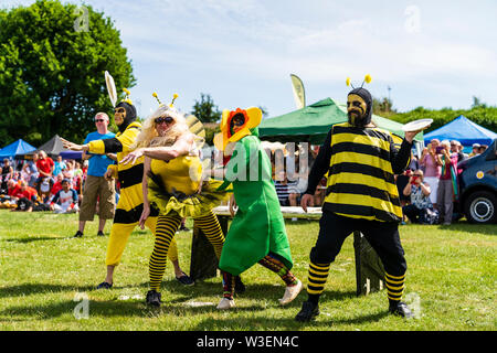 World Championship 2019 Tarte à la crème. L'équipe B habillé en robe de soirée comme les abeilles et une fleur, de lancer des tartes à la crème de table derrière eux. Banque D'Images