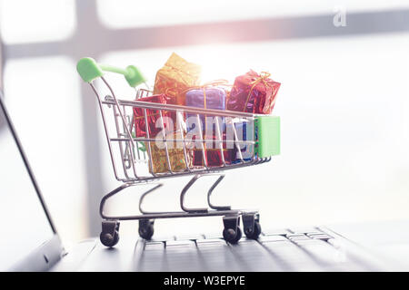 Les boîtes-cadeaux dans un panier sur un clavier d'ordinateur portable. Banque D'Images