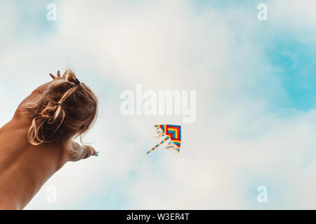 Heureux l'enfant jouant avec un cerf-volant, à l'enfant jusqu'à un cerf-volant multicolore en flèche dans le ciel, enfance heureuse, profitant des vacances d'été Banque D'Images