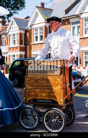 Broadstairs Dickens festival. Des gens habillés en costume d'époque victorienne. L'homme, orgue de barbarie, dans un style allemand costume, avec orgue de rue dans la rue. Banque D'Images