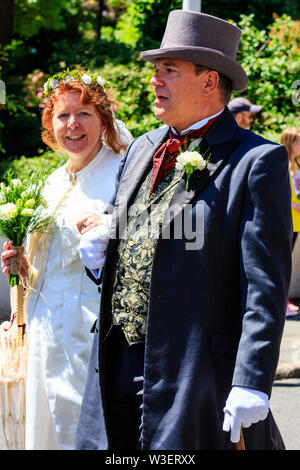 Broadstairs Dickens Festival. Des gens habillés en costume victorien. Portrait de l'homme et de la femme habillée en mariée et le marié se promener le long de la rue. Banque D'Images