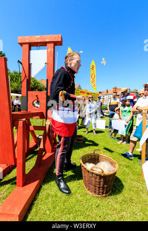 Broadstairs Dickens Festival. L'homme habillé en soldat de la révolution française à partir de 'Tale of Two Cities' explique aux gens comment fonctionne la guillotine. Banque D'Images