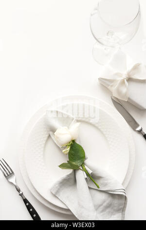 Réglage de la table de mariage et romantique avec White Rose, cadeau, vaisselle, couverts de table blanc. Vue d'en haut. Banque D'Images