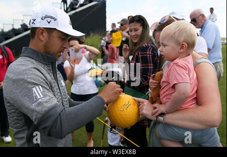 USA's Xander Schauffele (à gauche) signe des autographes au cours de l'aperçu de la deuxième journée de l'Open Championship 2019 au Club de golf Royal Portrush. Banque D'Images