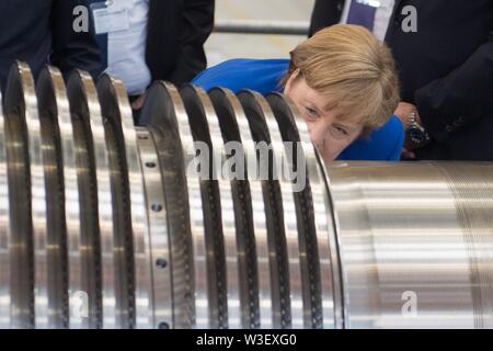 15 juillet 2019, Saxe, Görlitz : la Chancelière Angela Merkel (CDU) inspecte une turbine à l'usine Siemens à Görlitz. Un mois et demi avant l'élections de l'état de Saxe, Merkel visite l'usine de Siemens dans l'Etat libre de Saxe ainsi qu'une réunion du réseau de femmes dans la capitale de l'état. Photo : Sebastian Kahnert/dpa-Zentralbild/dpa Banque D'Images