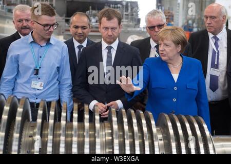 15 juillet 2019, Saxe, Görlitz : la Chancelière Angela Merkel (CDU) se trouve à côté de Michael Kretschmer (CDU, M), premier ministre de Saxe, à une turbine dans l'usine Siemens à Görlitz. Un mois et demi avant l'élections de l'état de Saxe, Merkel visite l'usine de Siemens dans l'Etat libre de Saxe ainsi qu'une réunion du réseau de femmes dans la capitale de l'état. Photo : Sebastian Kahnert/dpa-Zentralbild/dpa Banque D'Images