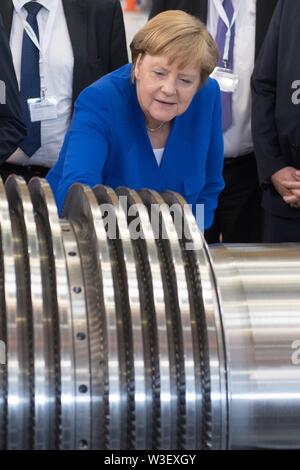 15 juillet 2019, Saxe, Görlitz : la Chancelière Angela Merkel (CDU) inspecte une turbine à l'usine Siemens à Görlitz. Un mois et demi avant l'élections de l'état de Saxe, Merkel visite l'usine de Siemens dans l'Etat libre de Saxe ainsi qu'une réunion du réseau de femmes dans la capitale de l'état. Photo : Sebastian Kahnert/dpa-Zentralbild/dpa Banque D'Images