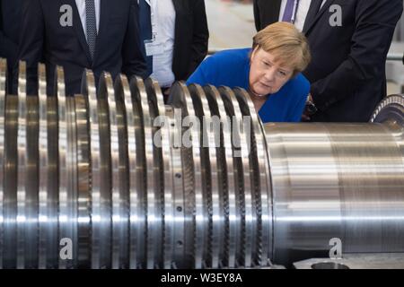 15 juillet 2019, Saxe, Görlitz : la Chancelière Angela Merkel (CDU) inspecte une turbine à l'usine Siemens à Görlitz. Un mois et demi avant l'élections de l'état de Saxe, Merkel visite l'usine de Siemens dans l'Etat libre de Saxe ainsi qu'une réunion du réseau de femmes dans la capitale de l'état. Photo : Sebastian Kahnert/dpa-Zentralbild/dpa Banque D'Images