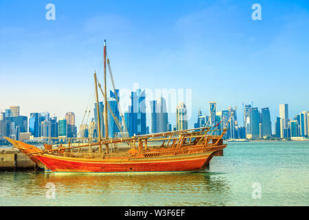 En dhow traditionnel en bois en premier plan avec front de mer de la baie de Doha et gratte-ciel de West Bay skyline sur arrière-plan. Capitale du Qatar, au Moyen-Orient Banque D'Images