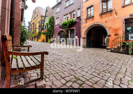 Lane de la destination touristique de Riquewihr, village de la Route des Vins d'Alsace, France, cobblestone lane avec décoration de fleurs et de vigne Banque D'Images