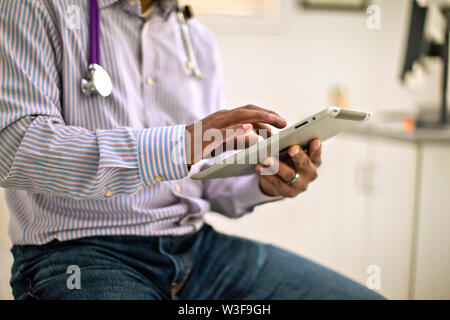 Mains d'un homme médecin à l'aide d'un iPad. Banque D'Images