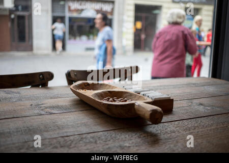 Belgrade, Serbie, 13 juillet 2019 : arachides sur une table dans le pub et les passants flous dans un arrière-plan Banque D'Images