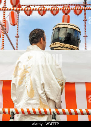 Un musicien japonais mâles, un batteur debout sur la scène Yagura est habillé en kimono traditionnel japonais maison de vacances et est titulaire d'un tambour taiko - prêt à Banque D'Images