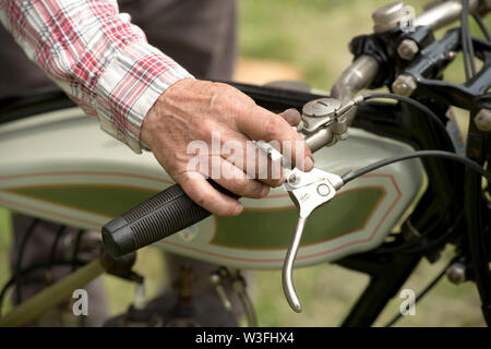 Man main tenant le guidon d'une moto vintage Banque D'Images