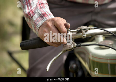 Man main tenant le guidon d'une moto vintage Banque D'Images