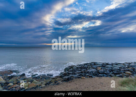 Lever du soleil à rocky Courtown Beach dans le comté de Wexford, en Irlande, le matin un ciel couvert Banque D'Images
