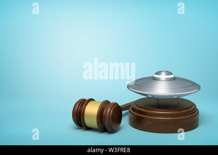 Le rendu 3D de l'argent métal OVNI sur bloc de bois rond et brown wooden gavel on blue background Banque D'Images