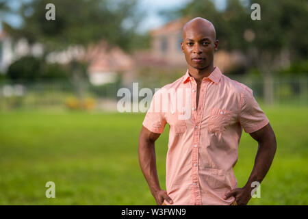 African American man posing in a pink shirt dans un ourdoors le parc cadre Banque D'Images